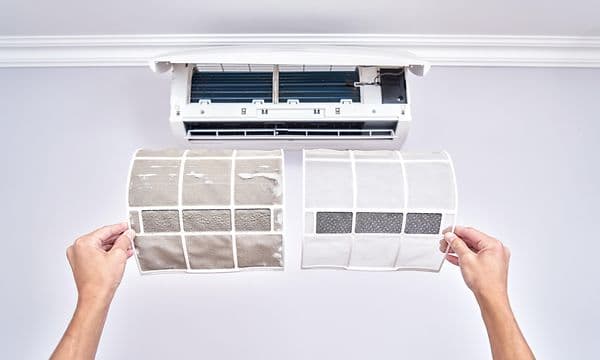 Aircondition och händer som håller upp ett smutsigt och ett rent filter