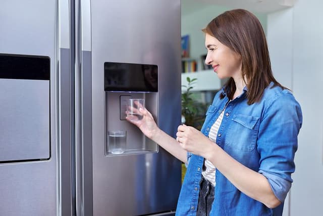 MDA-Fridges-Fridge with ice machine-Woman getting ice in glass from the fridge