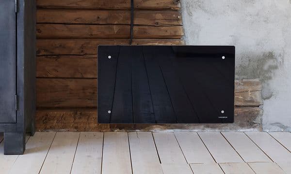 Sort radiator på en trævæg
