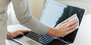 Computing - Laptop - Kvinde tørrer skærmen på sin laptop af