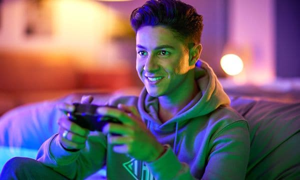 Gutt gamer med TV-lys i ansiktet