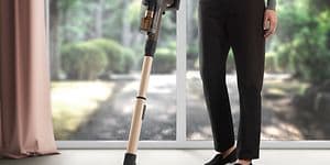 En person som dammsuger golvet med Electrolux skaftdammsugare