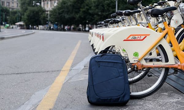 En ryggsäck på gatan framför cyklar