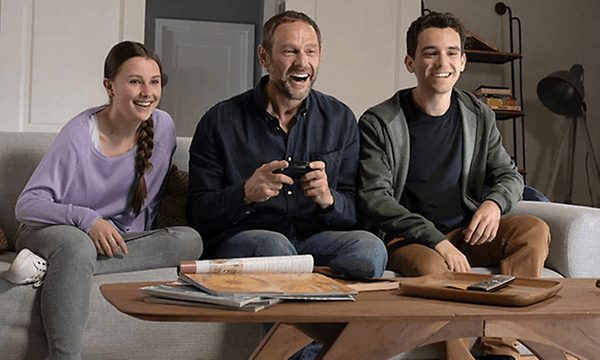 Nintendo Switch - mann og to barn gamer sammen i en sofa
