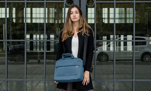 kvinne holder en blå pc-veske