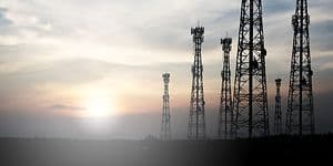 en soloppgang bak noen høye 5G-antenner