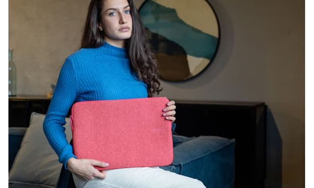 Kvinde der holder en lyserød computertaske