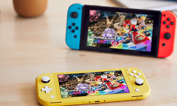 Två Nintendo Switch-konsoler på ett bord. En liten gul Nintendo Switch Lite och en större röd och blå NintendoSwitch. 