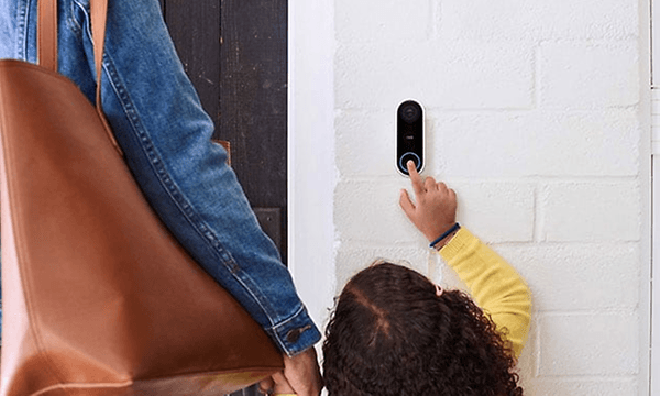 En liten flicka / ett barn ringer på en smart dörrklocka 
