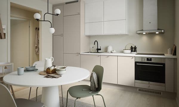 Trend Greige køkken i lys beige og hvidt, med rundt spisebord foran.
