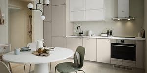 Trend Greige køkken i lys beige og hvidt, med rundt spisebord foran.