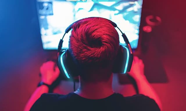 Ung dreng sidder foran en computer og spiller et spil
