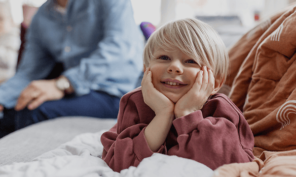 5 tips när du ska köpa ny TV:  Glad unge och hans familj i bakgrunden.