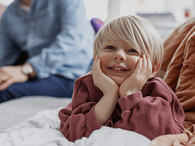 5 tips när du ska köpa ny TV: Glad unge och hans familj i bakgrunden.