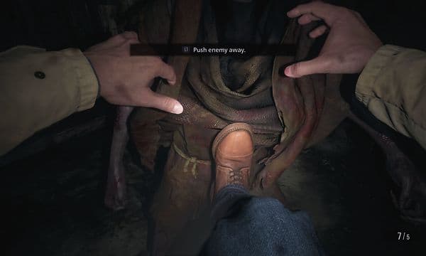 Screenshot från spelet där Ethan sparkar bort en fiende