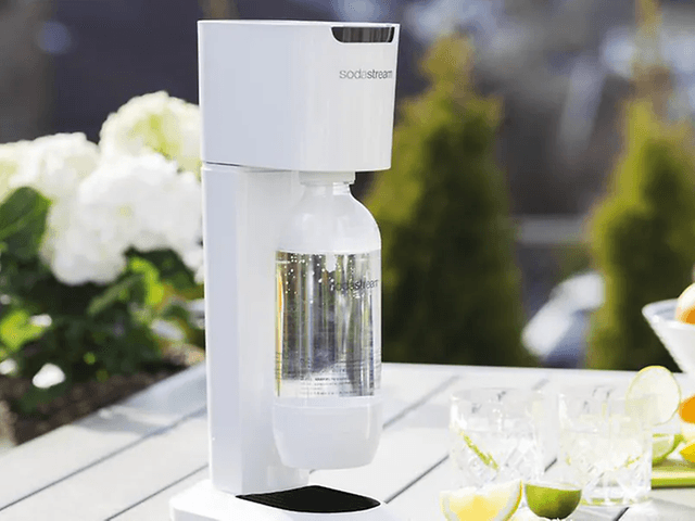 Valkoinen Sodastream puutarhapöydällä sitrushedelmien vieressä