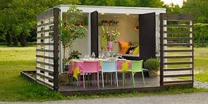 Havepavillion med farverige stole og et bord dekoreret  til fest