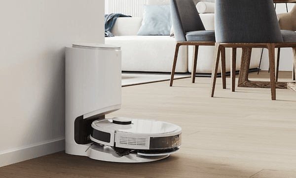 Ecovacs DEEBOT-N8 plus i en ladestasjon plassert i en lys stue