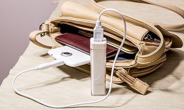 Tynd powerbank oplader en smartphone som ligger i en håndtaske