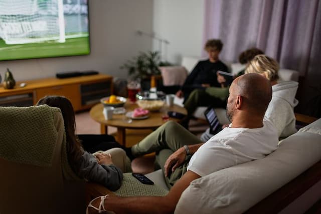 Familie i sofa ser tv