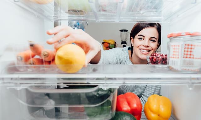 MDA-Fridges-Woman reaching for a lemon in a fridge