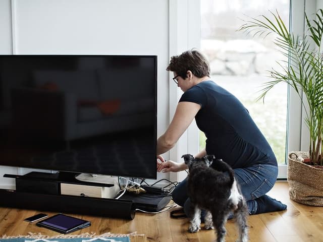 Nainen tarkistaa televisiota