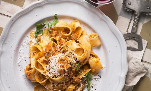 Hjemmelaget pasta på tallerken og et glass med drikke