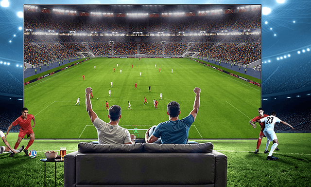 Familie i sofa ser på sport på TV