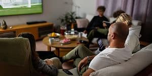 Familie i sofa ser på sport på TV