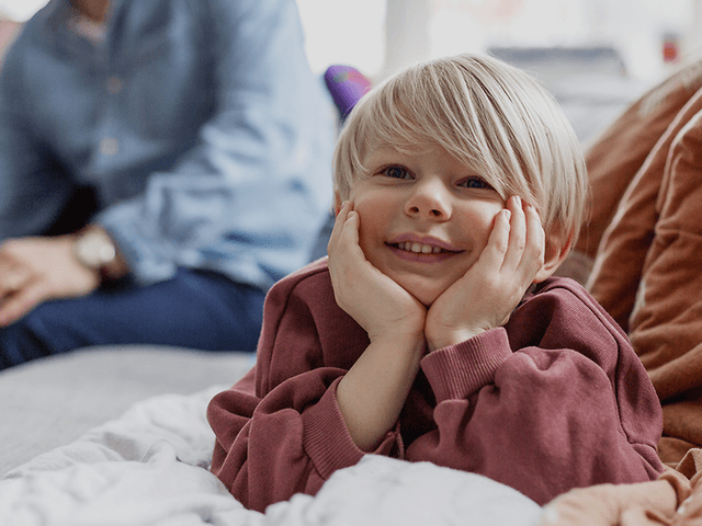 Five tips for buying a new TV:  Happy kid and his family in the background.
