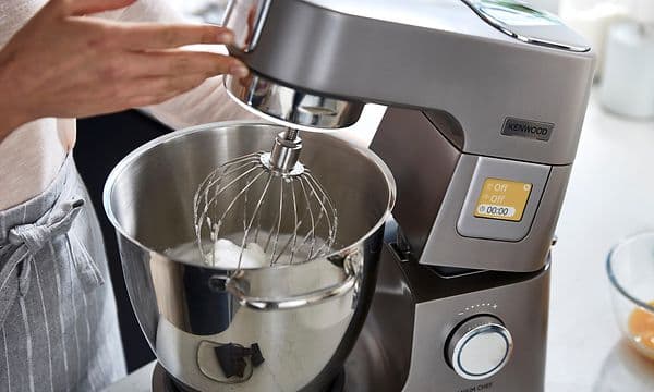 En kvinna lyfter huvudet på en Kenwood Chef XL Patissier med integrerat ljus