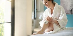 kvinne barbarer leggene med en elektrisk barbermaskin