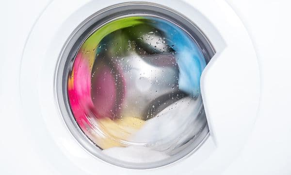 MDA-Washing machine-Tvättmaskin med färgglada kläder som tvättas inuti