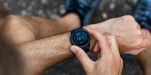 en mann sjekker smartklokke på håndledd