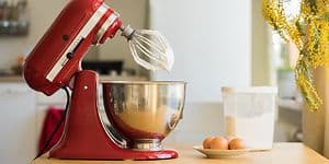 KitchenAid kjøkkenmaskin på kjøkkenbenk med egg og boks med sukker