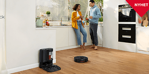 Roborock S7Max på golvet i ett kök där ett par pratar