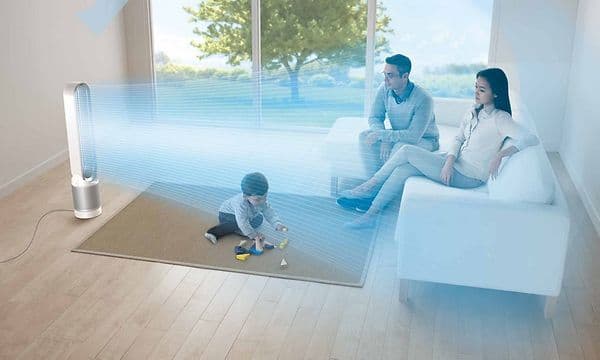 En Pure Cool Tower PP00 sender ut og fordeler ren blå luft mot en familie som sitter på en sofa og et barn på gulvet