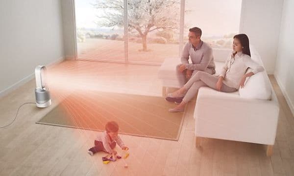 En Pure Cool Tower PP00 och illustrerade röda strålar mot ett par som sitter i en soffa och ett barn som leker bredvid