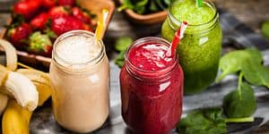 Kolme lasillista smoothieta ja hedelmiä