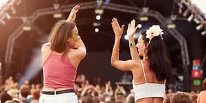 Tytöt konsertissa ihmisjoukon keskellä