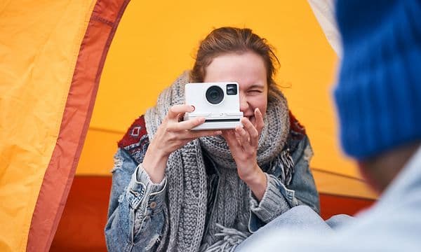 en kvinne tar bilde med et polaroidkamera