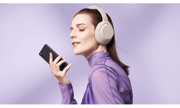 Kuulokkeet päässä oleva nainen sekä Xperia 10 -älypuhelin