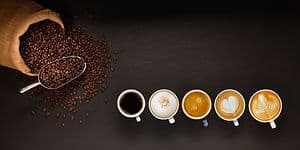 Kaffemaskine-guide: Kaffebønner og kaffekopper set ovenfra