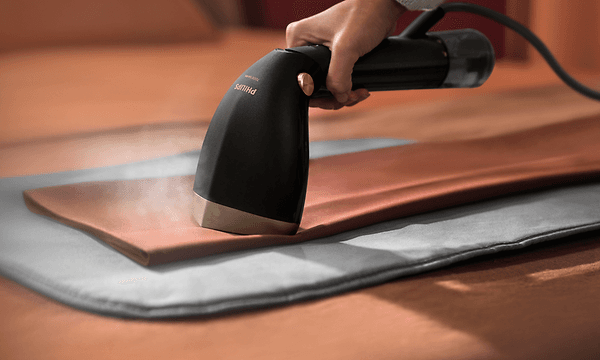 Person som steamar byxor med Philips Steamer 7000