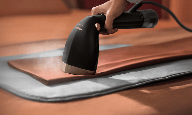 Person som steamar byxor med Philips Steamer 7000