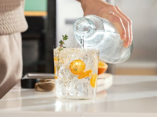 Danskvand med SodaStream: Person hælder danskvand i et glas