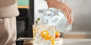 Danskvand med SodaStream: Person hælder danskvand i et glas