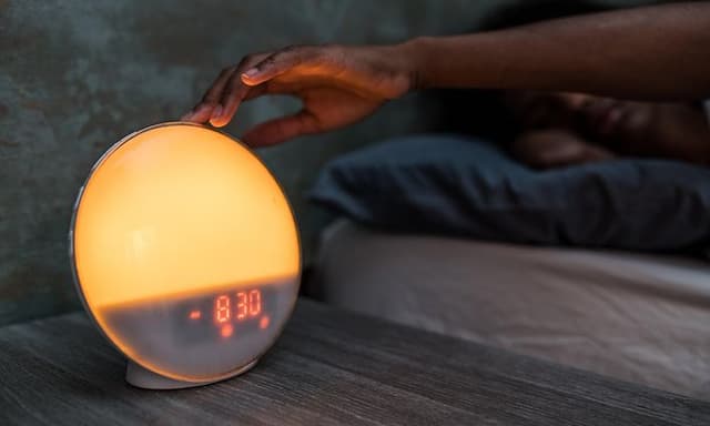 Få din gode døgnrytme tilbage: En hånd trykker på wakeup light fra Philips