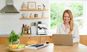 Woman using laptop in kitchen