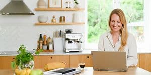 Woman using laptop in kitchen